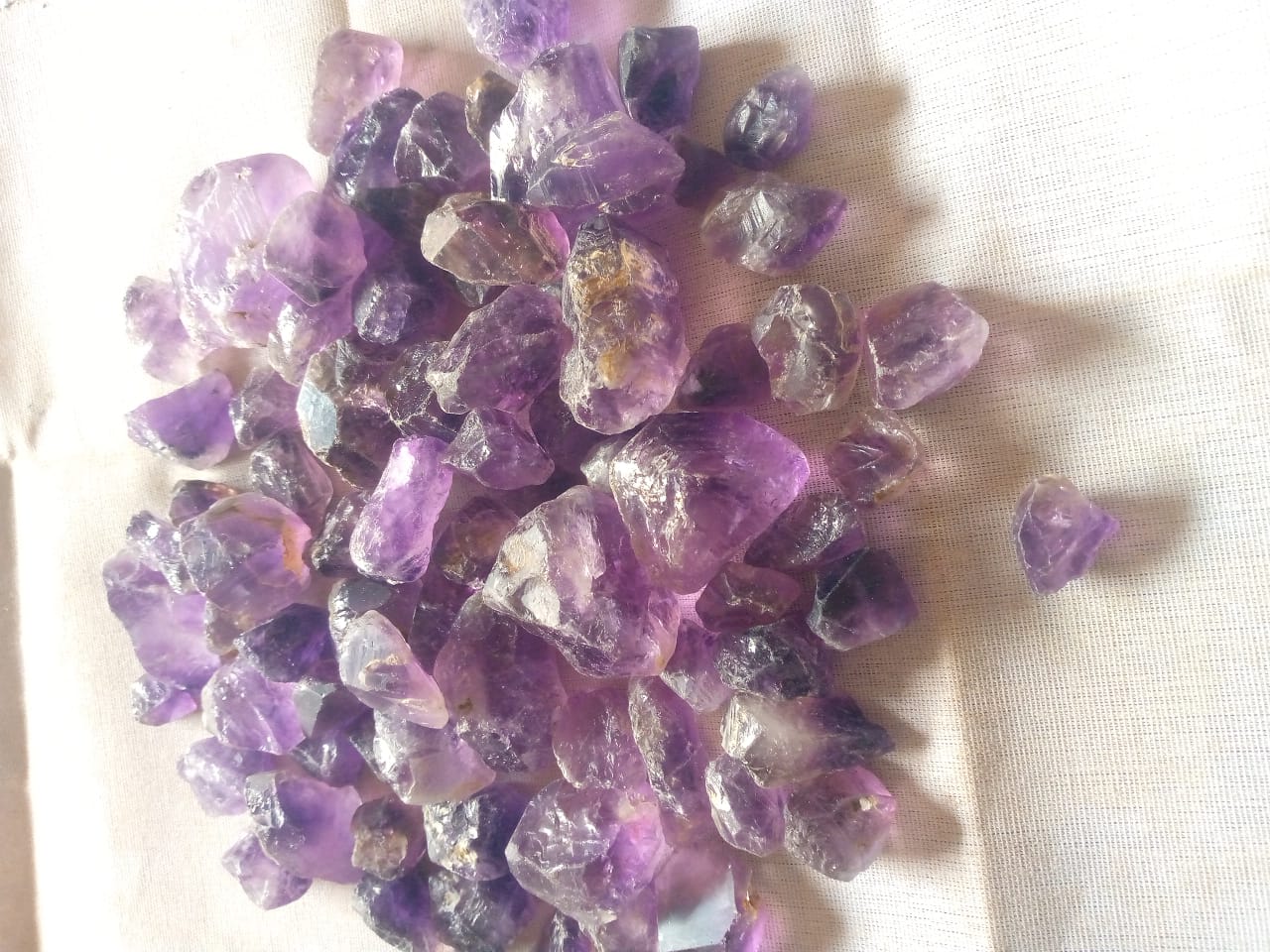 Clear and lightly colored rough stones displayed on fabric